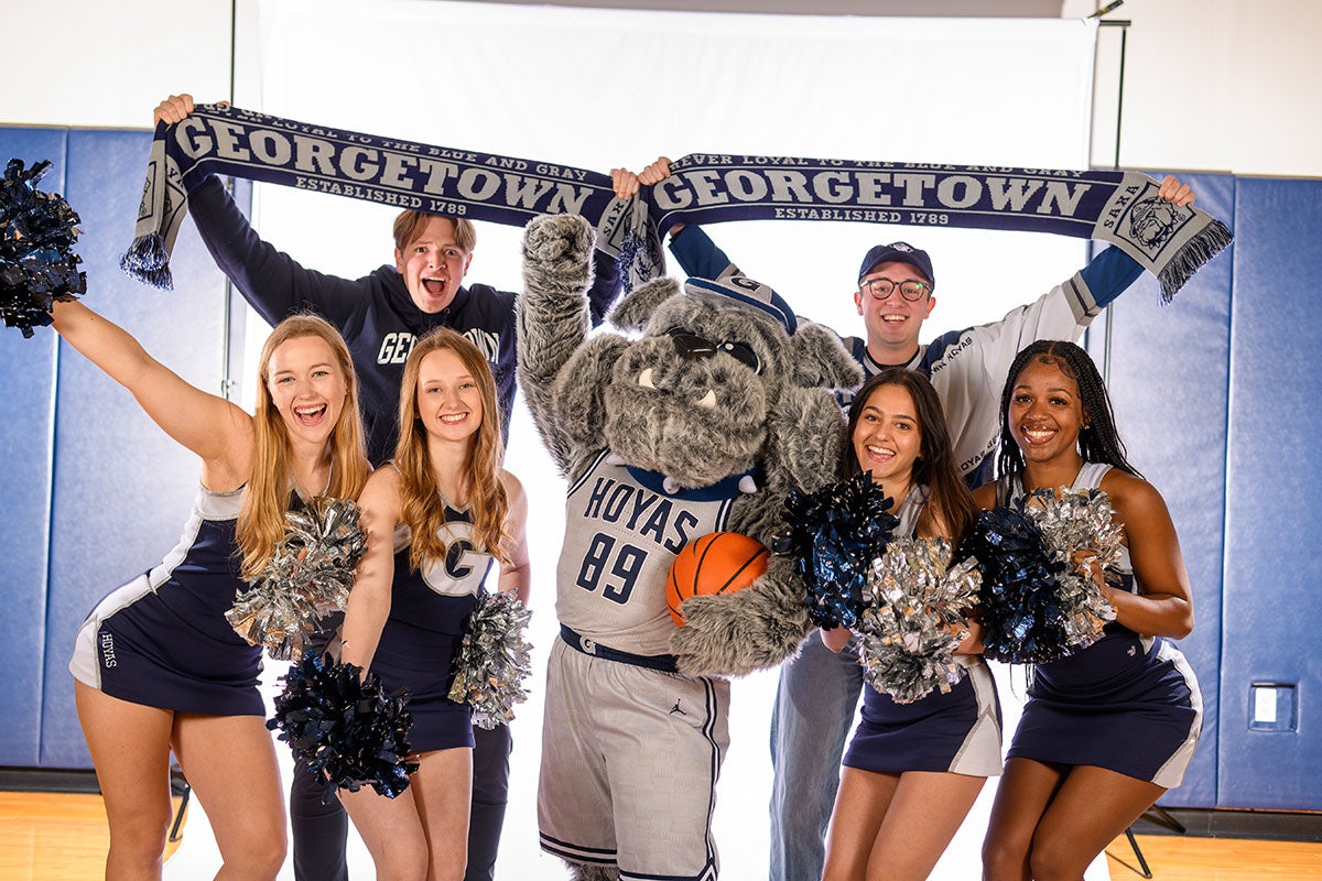 cheerleaders, the Jack the Bulldog costume mascot, and fans holding Georgetown scarves